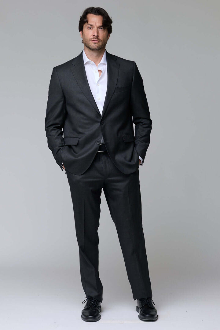 Homme portant un complet classique deux pièces noir, incarnant l'élégance intemporelle et le confort pour les événements formels.