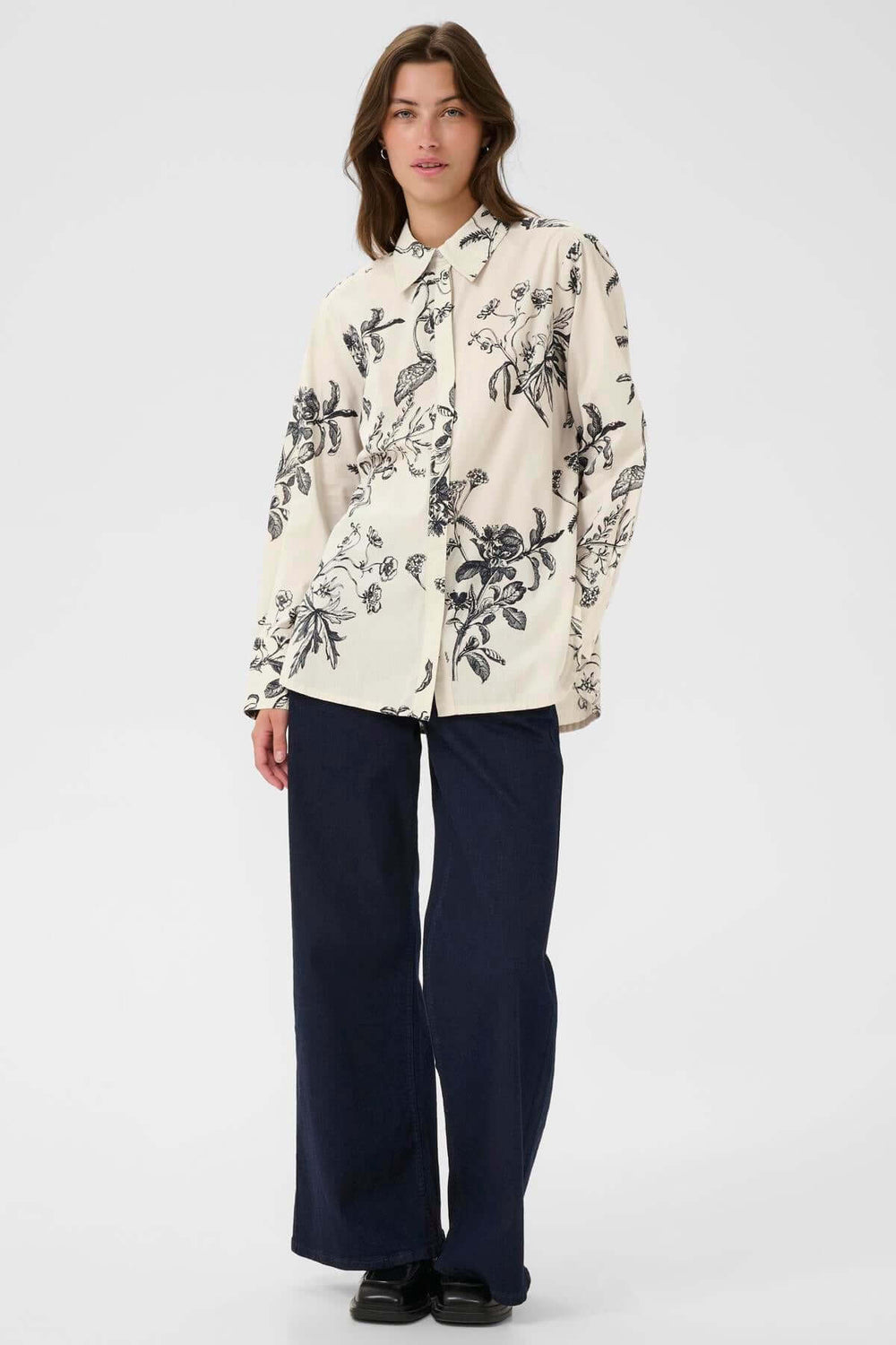 Femme portant la blouse Sveja à imprimé floral, col chemise, look chic et confortable.