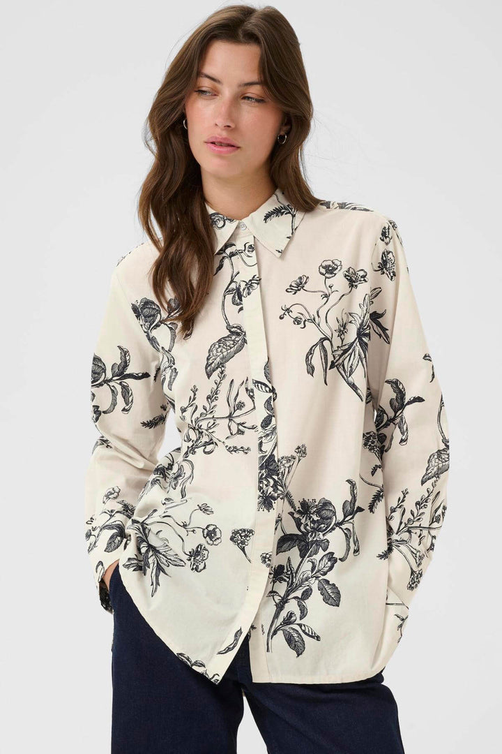 Blouse Sveja à imprimé floral avec col chemise, élégante et polyvalente, portée par une femme, idéale pour bureau ou sorties.