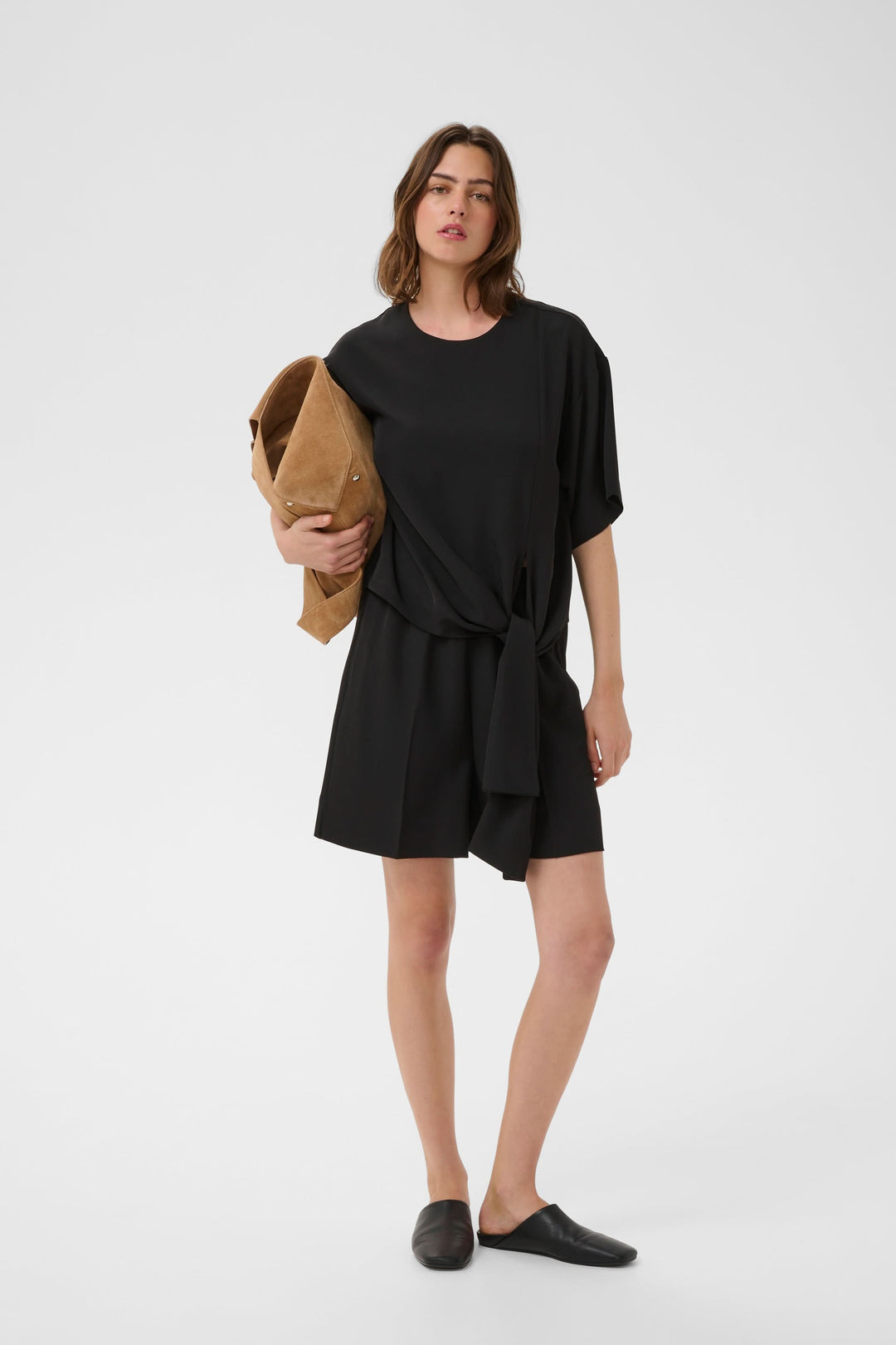 Femme portant Bermuda Varina fluide taille élastique ceinturé en noir, style moderne et souple, avec ceinture intégrée.