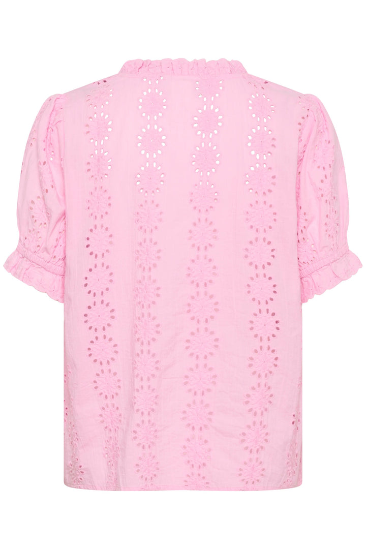 Blouse Dona brodée à manches courtes avec encolure volantée en tissu rose avec broderies ajourées et ourlet élastiqué.