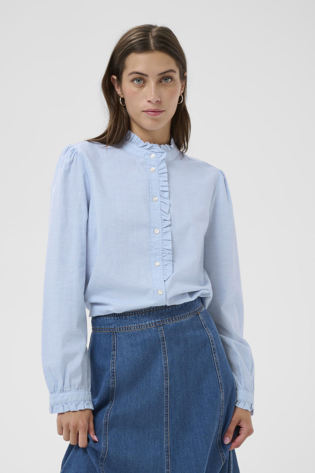 Blouse Glessia romantique avec volants subtils, coupe fluide et col montant, idéale avec un jean ou une jupe.