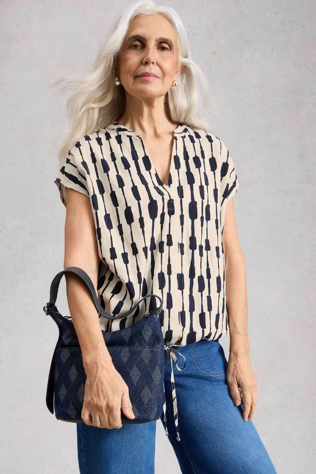 Blouse Nicole en lin mélangé avec imprimé graphique et encolure en V, portée par une femme, manches courtes, style décontracté.