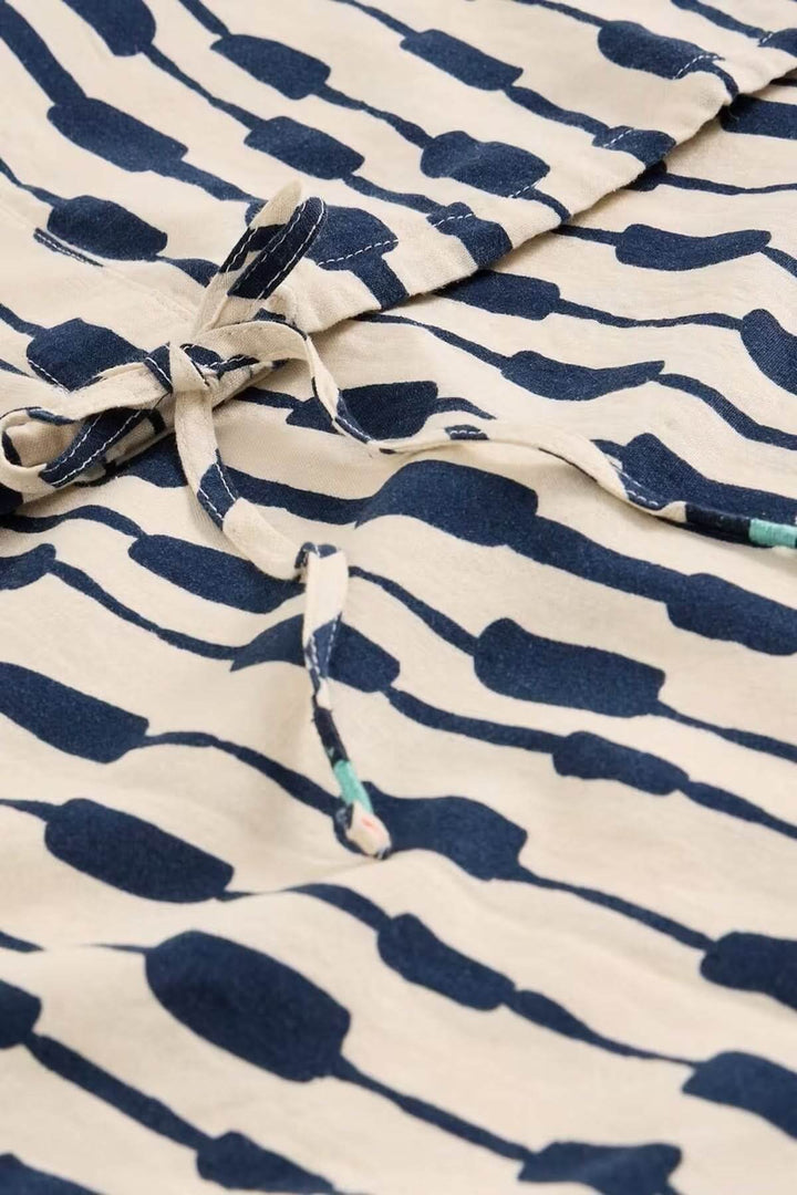 Blouse Nicole en lin mélangé avec imprimé graphique moderne et lien à nouer observée de près, style raffiné et décontracté.