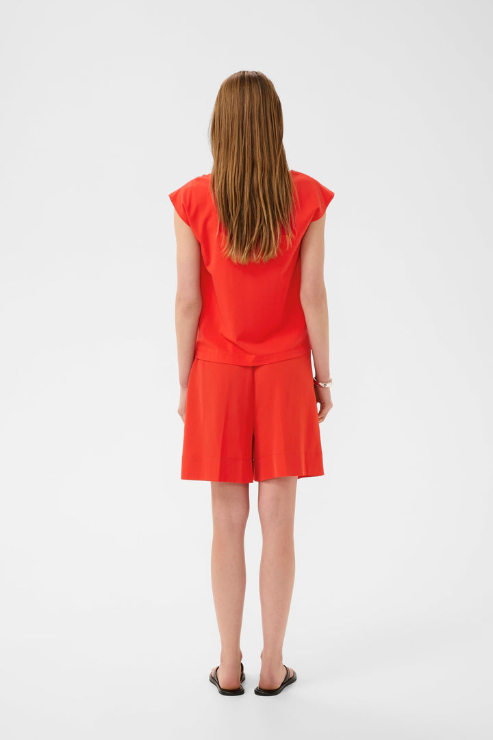 Vue arrière de la Blouse Pennie fluide à encolure drapée portée par un mannequin, offrant une coupe fluide et moderne.