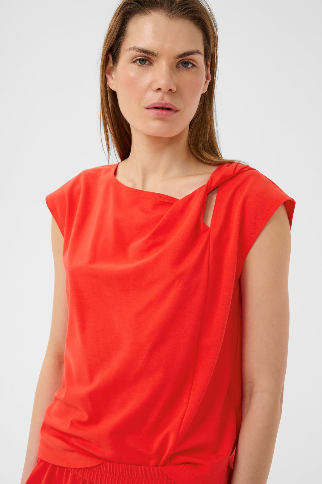 Femme portant Blouse Pennie fluide à encolure drapée rouge avec manches courtes et ouverture subtile