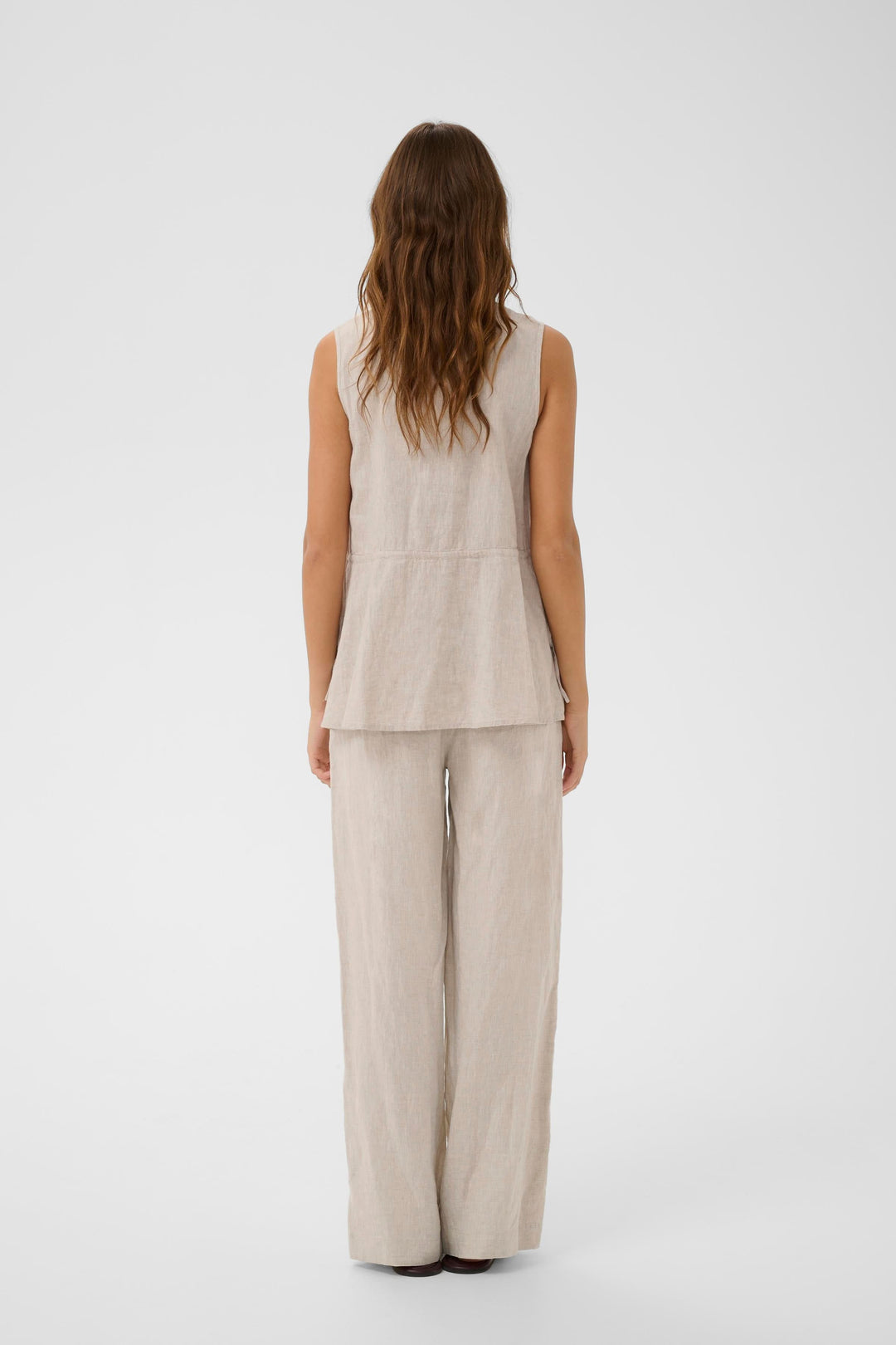 Blouse Rowan sans manches en lin avec coupe fluide et épurée, dos visible sur mannequin, facile à agencer avec différents styles.