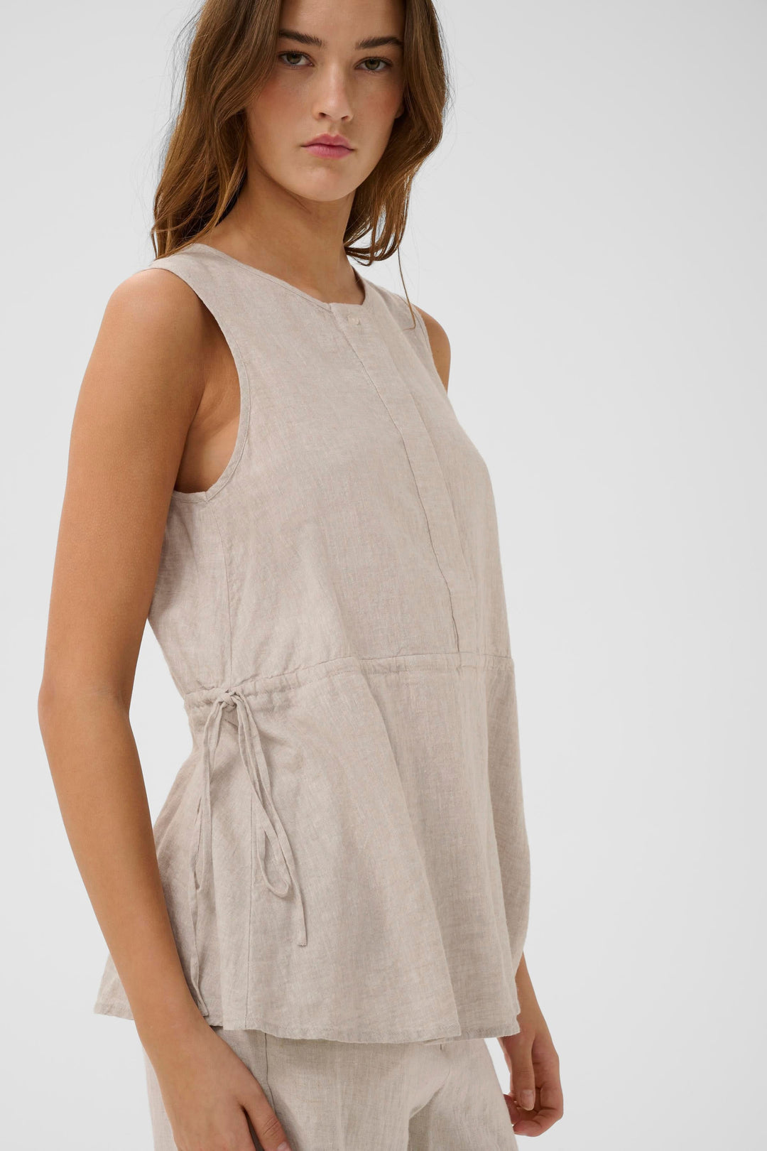 Blouse Rowan sans manches en lin, silhouette épurée et naturelle, tissu léger et respirant, coupe fluide moderne.