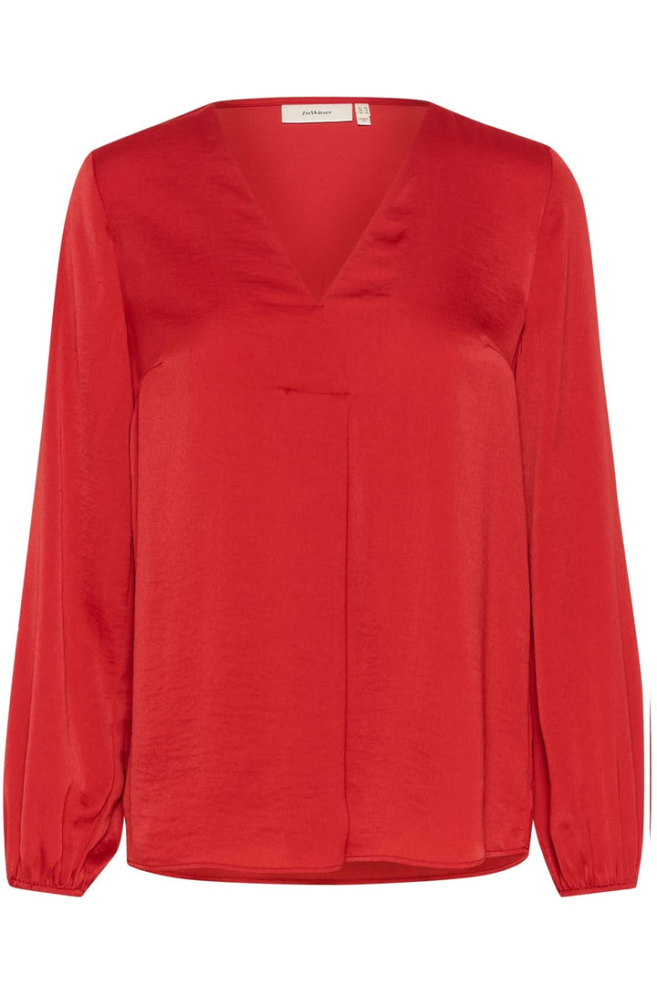 Blouse col en V Rinda rouge, coupe ample, manches longues avec poignets ajustés, style élégant et moderne.