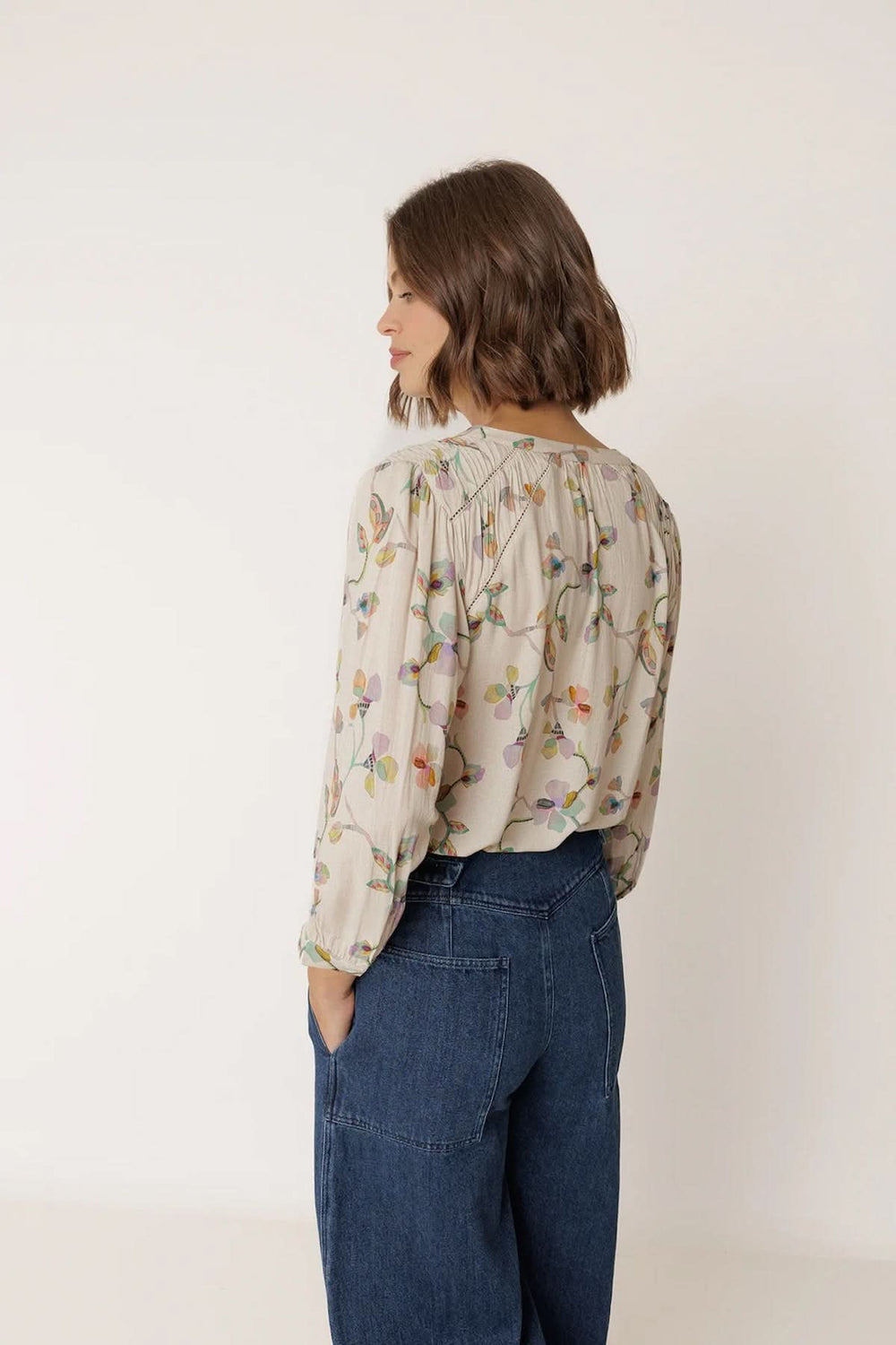 Vue arrière de la Blouse florale à manches longues avec imprimé floral délicat et fronces aux épaules pour un look élégant.