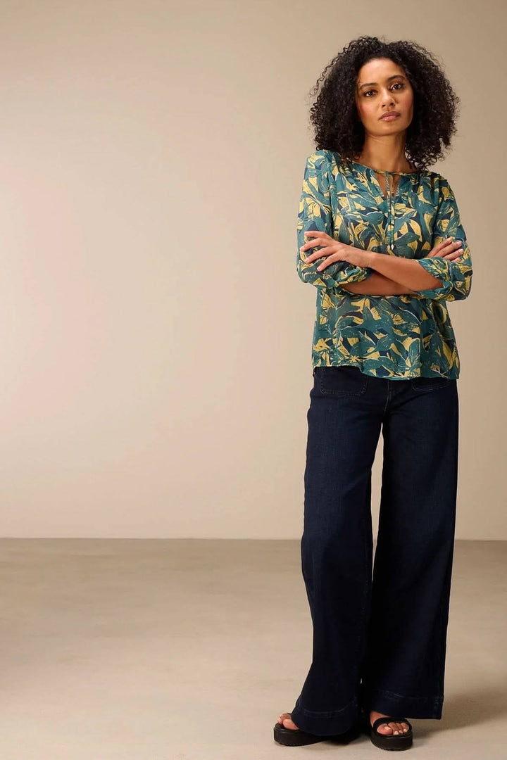Blouse fluide imprimé avec manches 3/4 et encolure fendue, offrant un style moderne et décontracté pour une tenue quotidienne élégante.