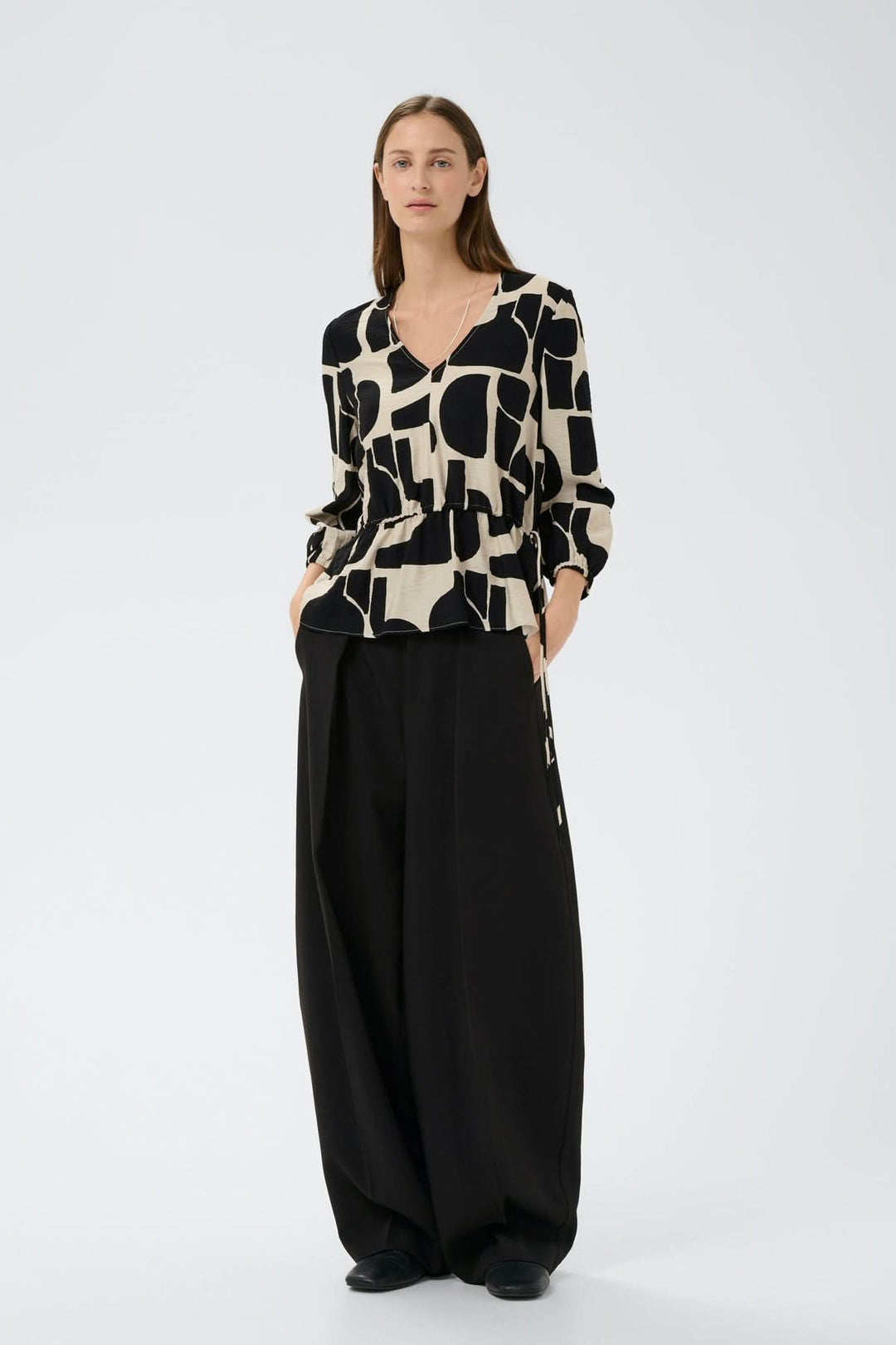 Blouse imprimée taille ajustable Lyn portée par mannequin, manches ¾ bouffantes, col en V, motif graphique, silhouette fluide.