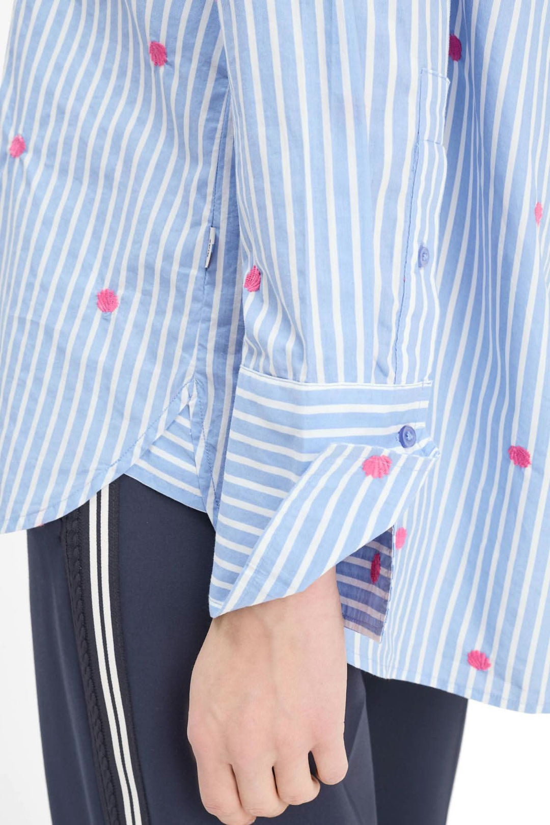 Blouse rayée à broderies contrastantes VIKI avec manches et boutons visibles, détails broderies délicates, style moderne et fluide.