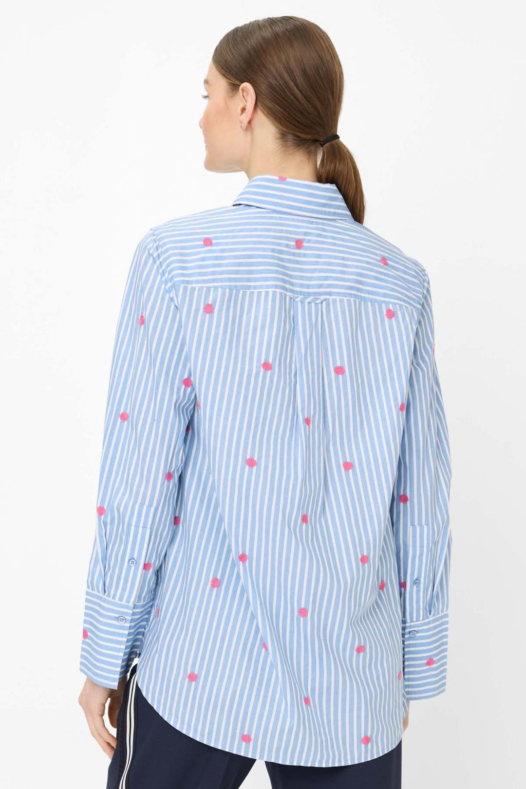 Blouse rayée à broderies contrastantes VIKI avec motif rayé bleu et broderies roses, vue arrière, portée par une femme.