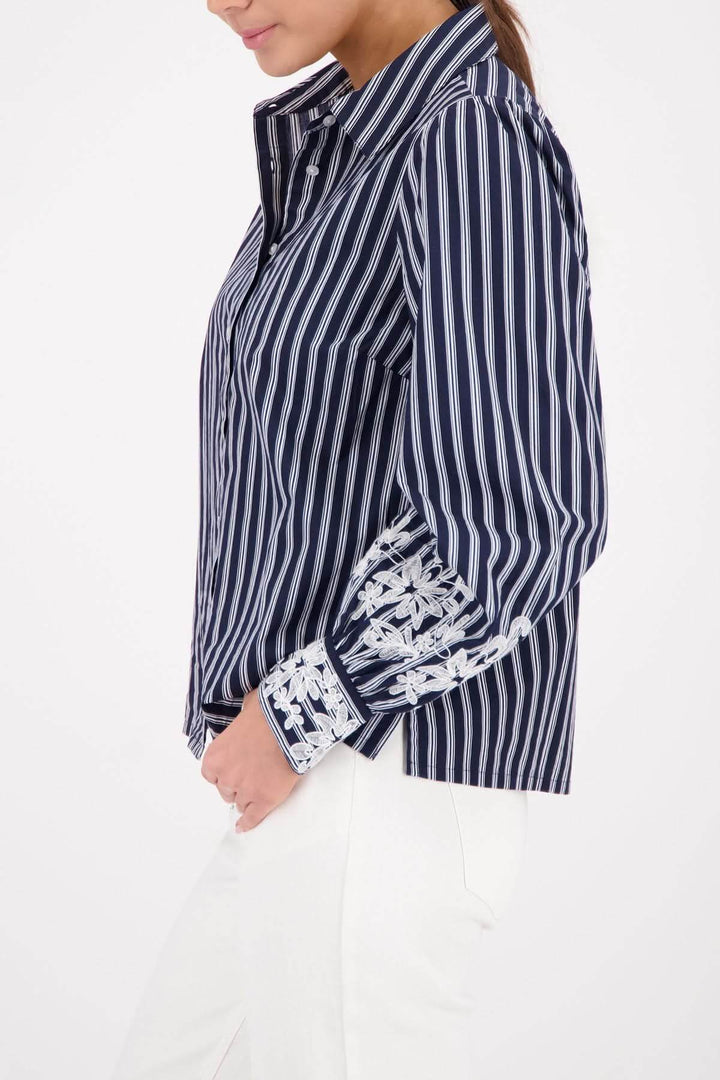 Blouse à rayures avec broderies florales sur poignets, col classique, motif intemporel, élégante et féminine pour travail ou décontracté.