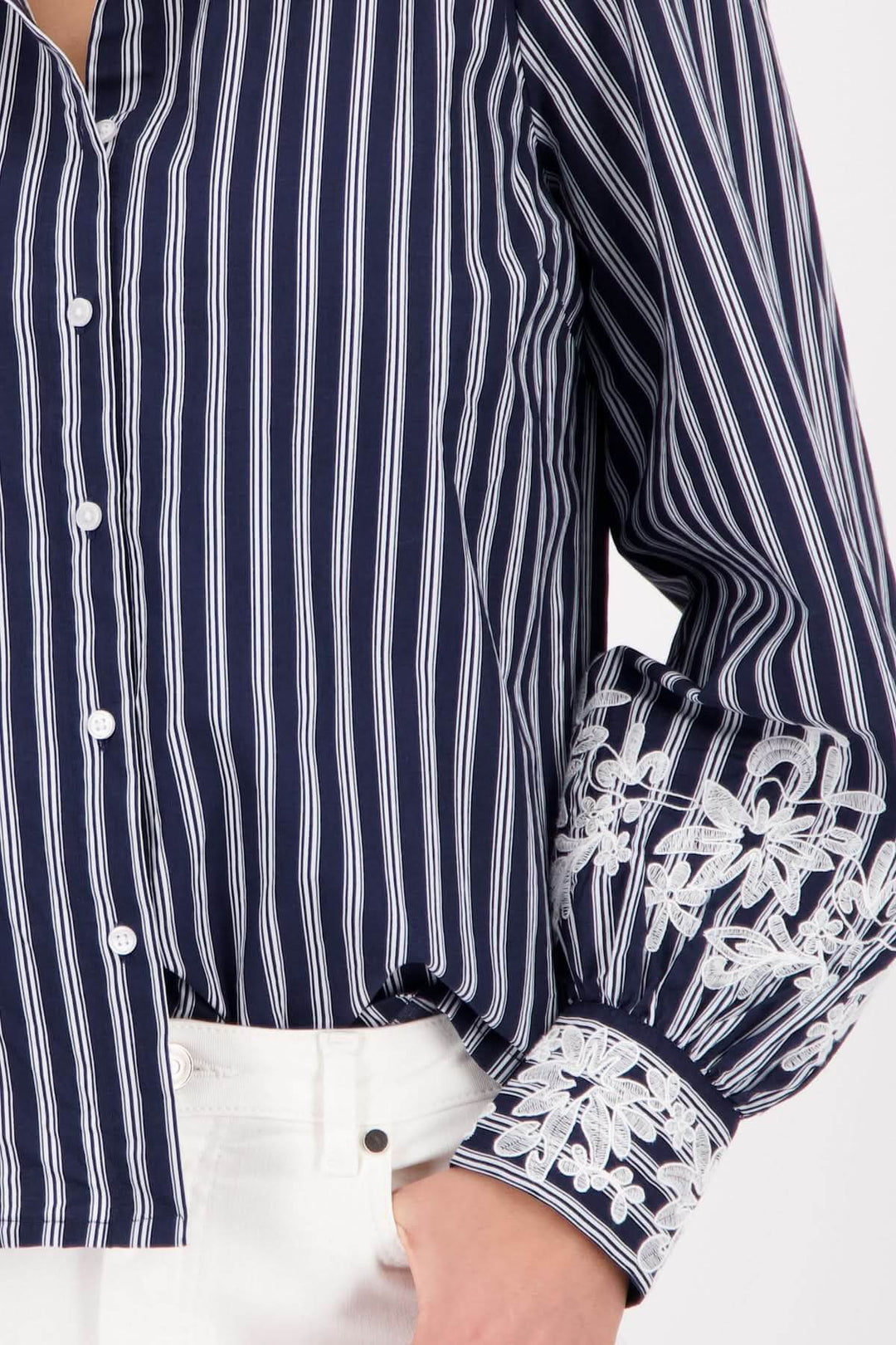 Blouse à rayures avec broderies florales sur les poignets, élégante et raffinée pour un look chic et décontracté.