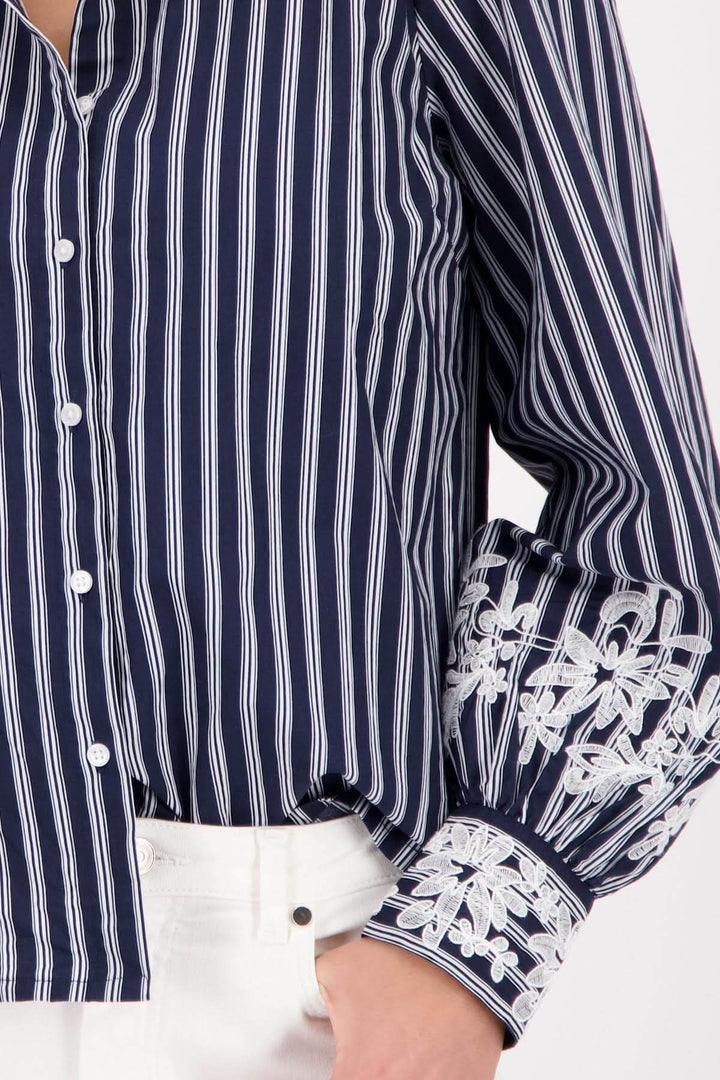 Blouse à rayures avec broderies florales sur les poignets, élégante et raffinée pour un look chic et décontracté.