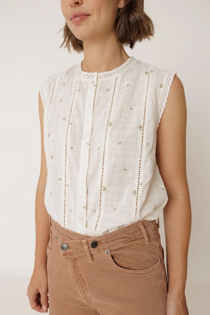 Blouse sans manches à détails ajourés avec bordure festonnée et bandes verticales. Élégante et féminine pour une allure délicate.
