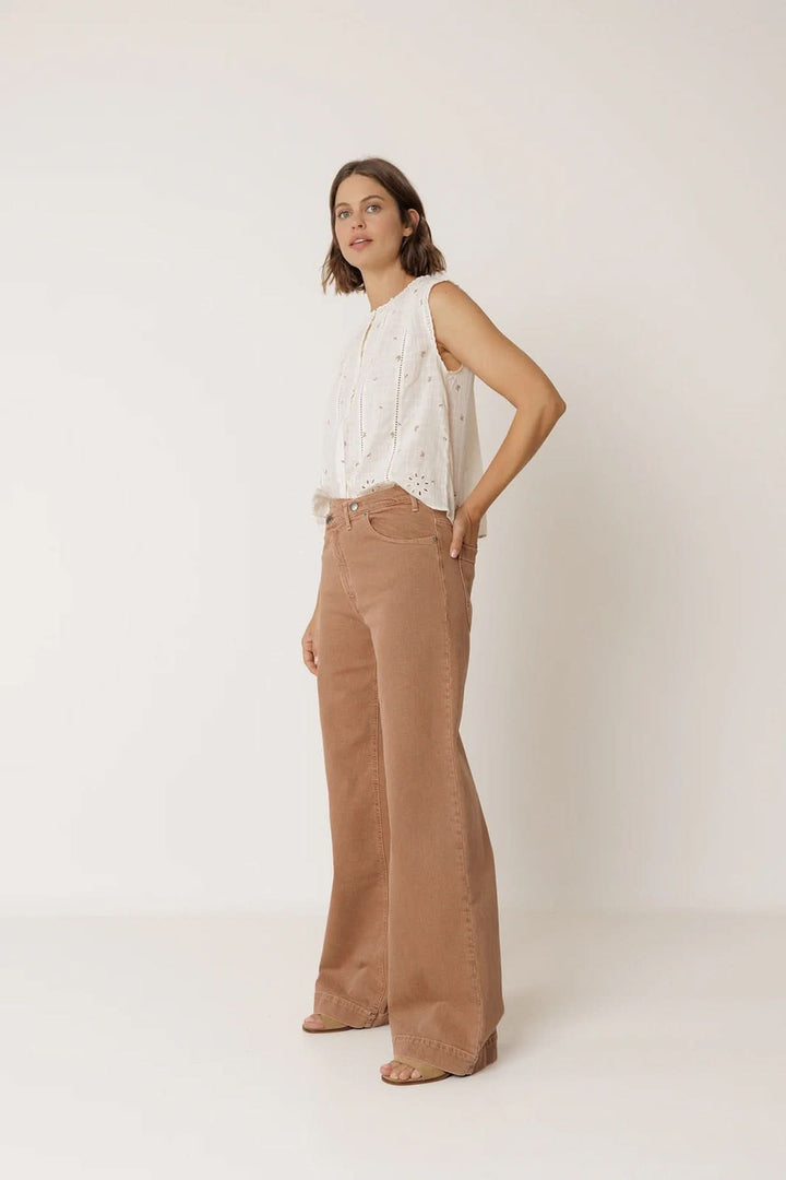 Femme portant une blouse sans manches à détails ajourés avec un pantalon large