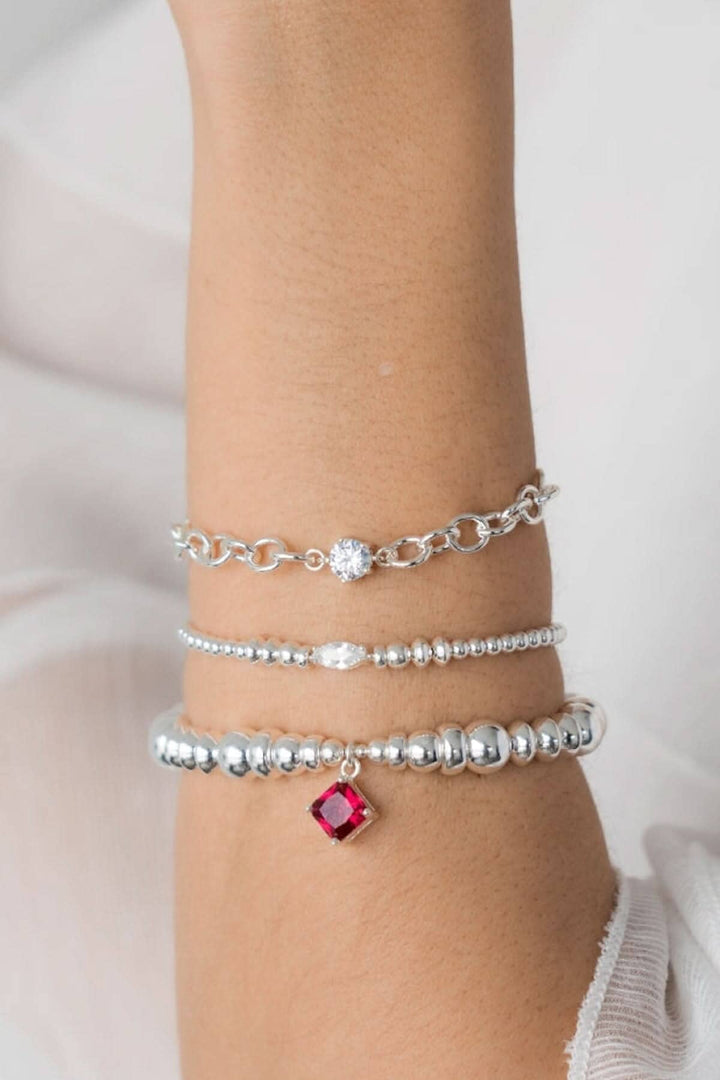 Bracelet en argent Be Sensational avec breloque en zirconium et rouge sur un poignet élégant.