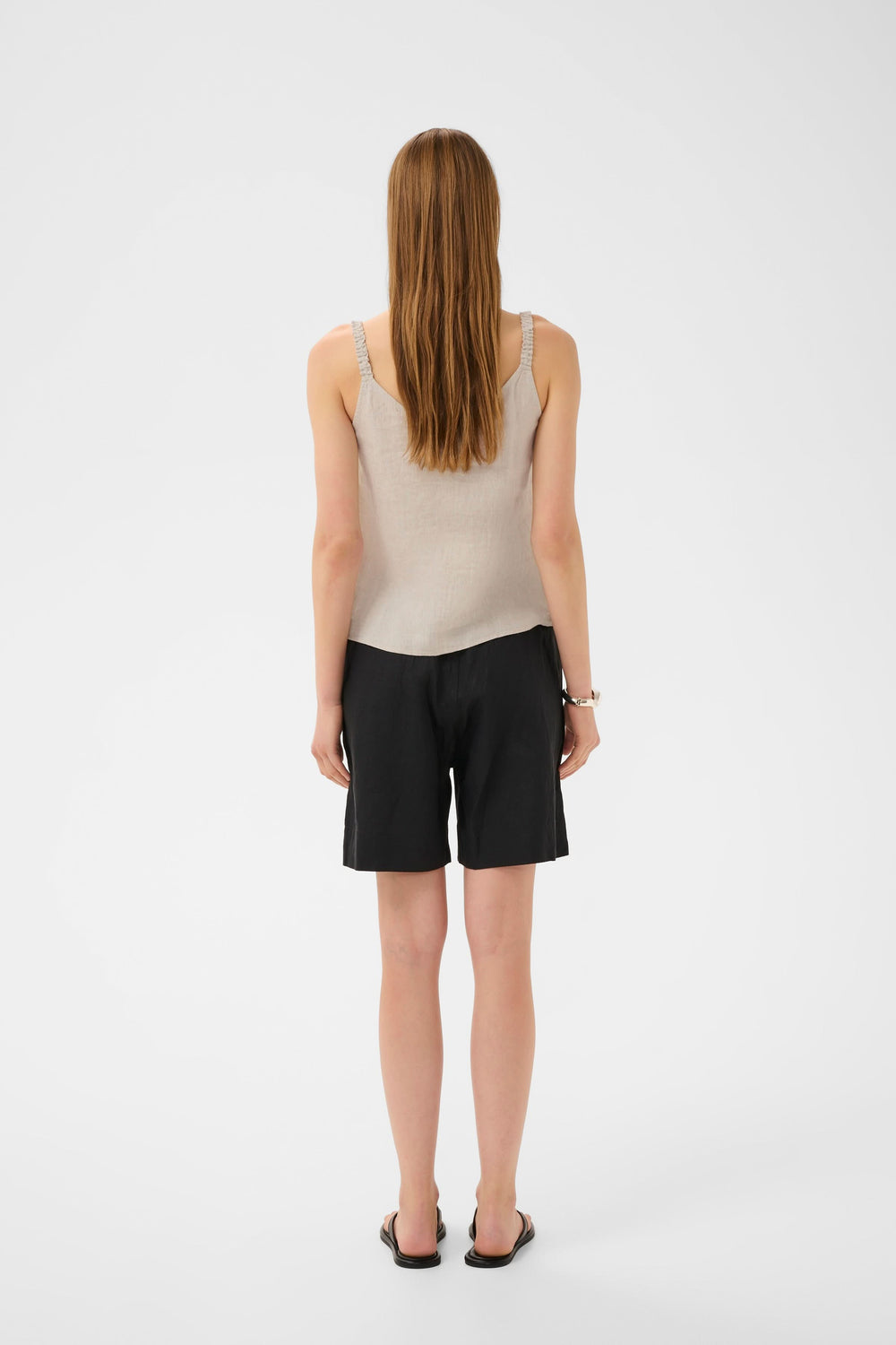 Person wearing Camisole Elinor fluide à bretelles fines, showing back view of outfit, featuring V-neckline and thin straps.