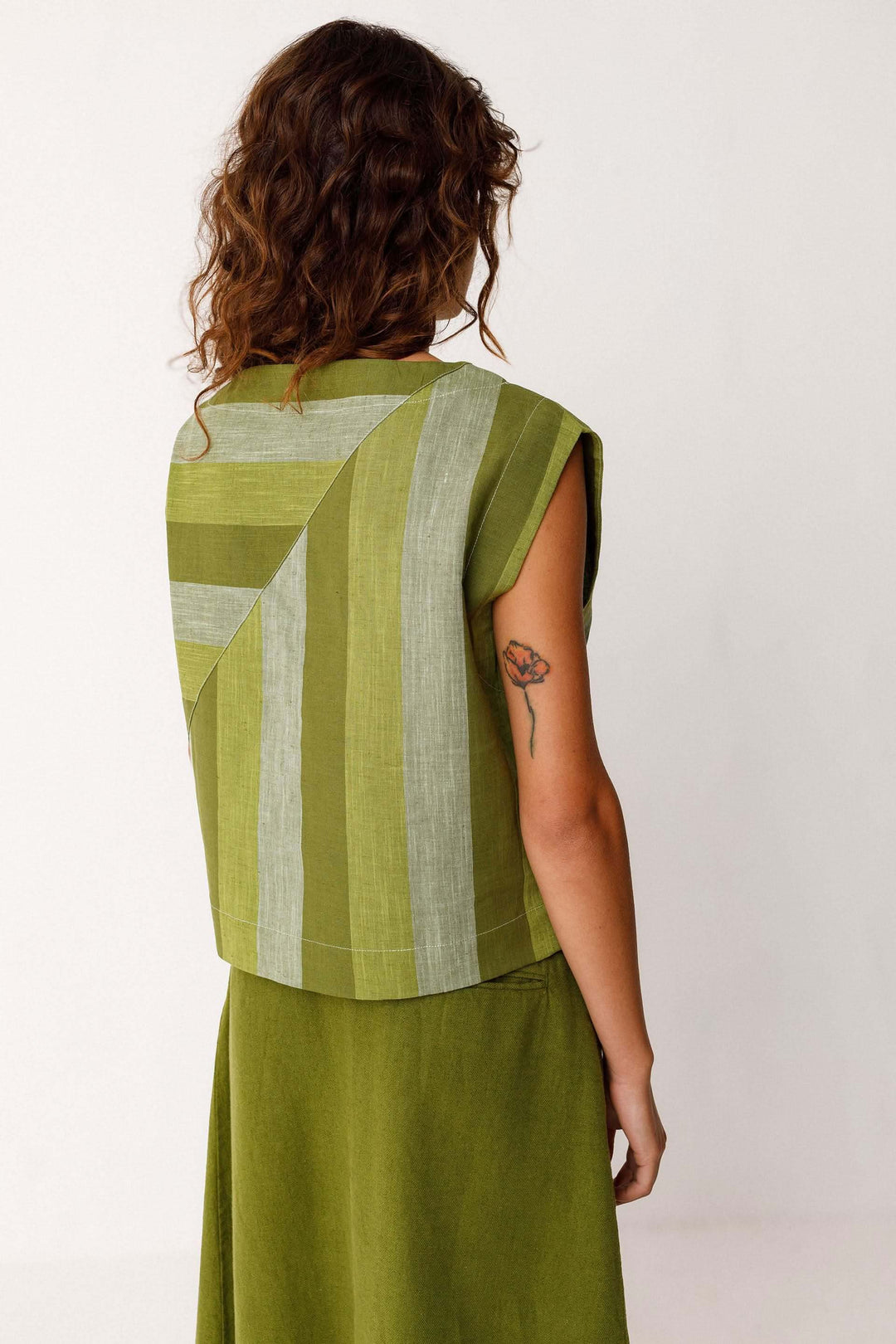 Femme portant la Camisole Lesia structurée sans manches motif graphique, vue de dos, en tissu léger et confortable, design moderne.