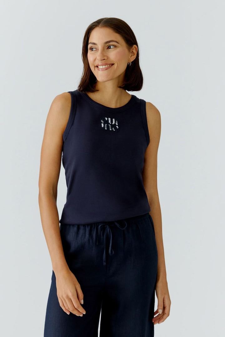 Femme portant une camisole ajustée avec détail graphique, coupe féminine et silhouette épurée idéale pour le quotidien.