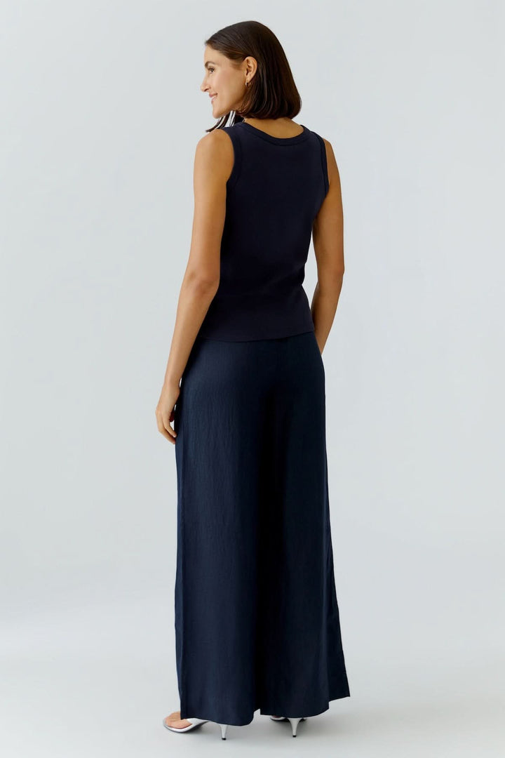 Femme portant une camisole ajustée avec détail graphique, vue de dos, en tenue élégante et moderne, parfaite pour le quotidien.