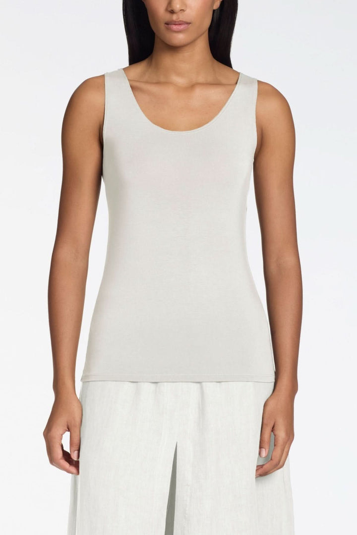 Camisole ajustée en maille douce, coupe ajustée, encolure arrondie sans manches, finition lisse. Décris moi le produit en français.