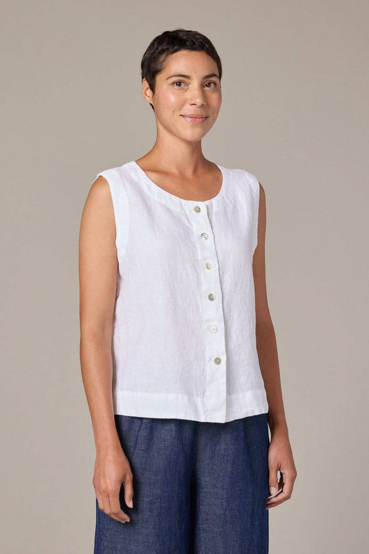Femme portant une camisole boutonnée en lin sans manches avec encolure ronde et coupe droite.