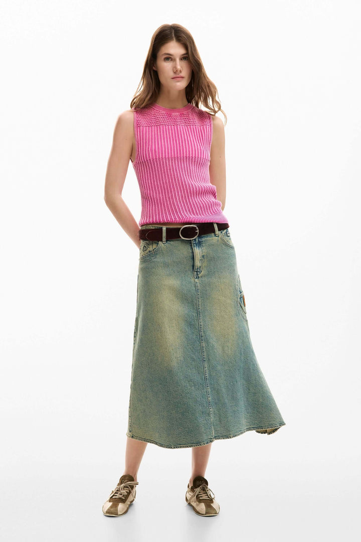 Femme portant une camisole crochet rose avec une jupe en jean vintage, look d&