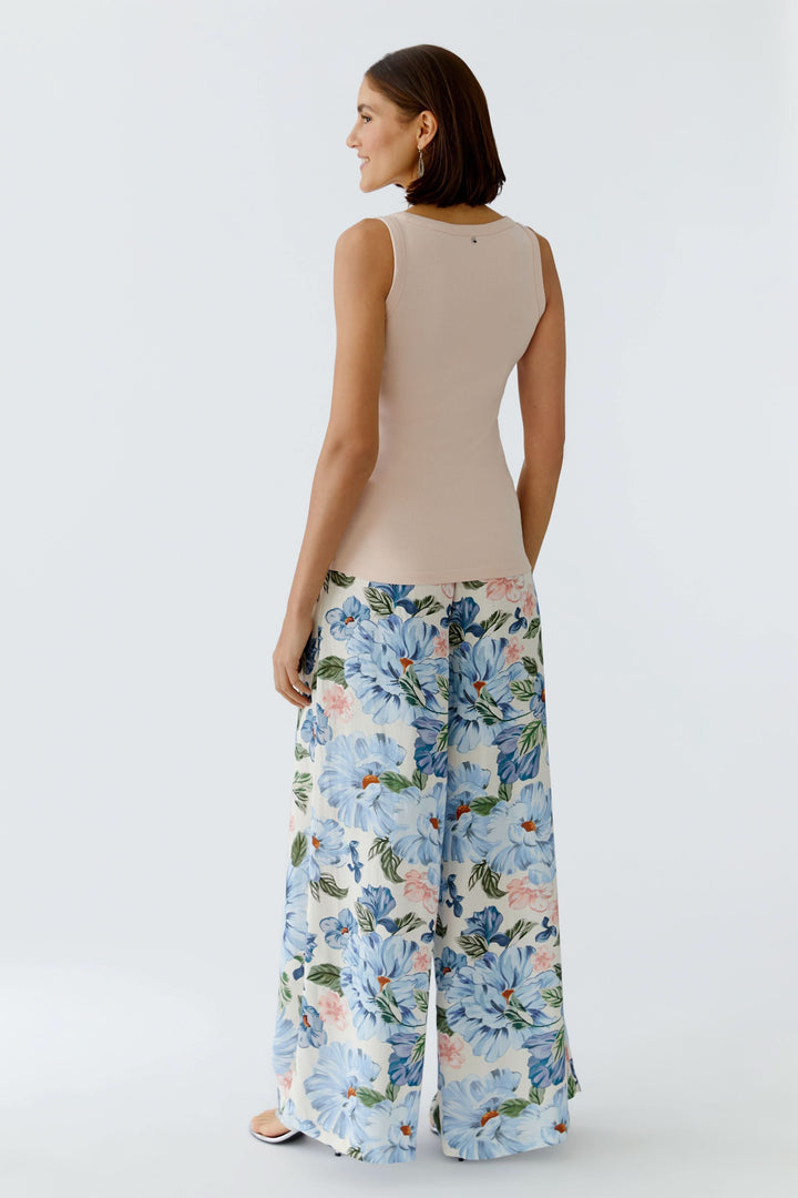 Femme portant une camisole côtelée essentielle ajustée avec des pantalons à fleurs, vue de dos, style décontracté et polyvalent.
