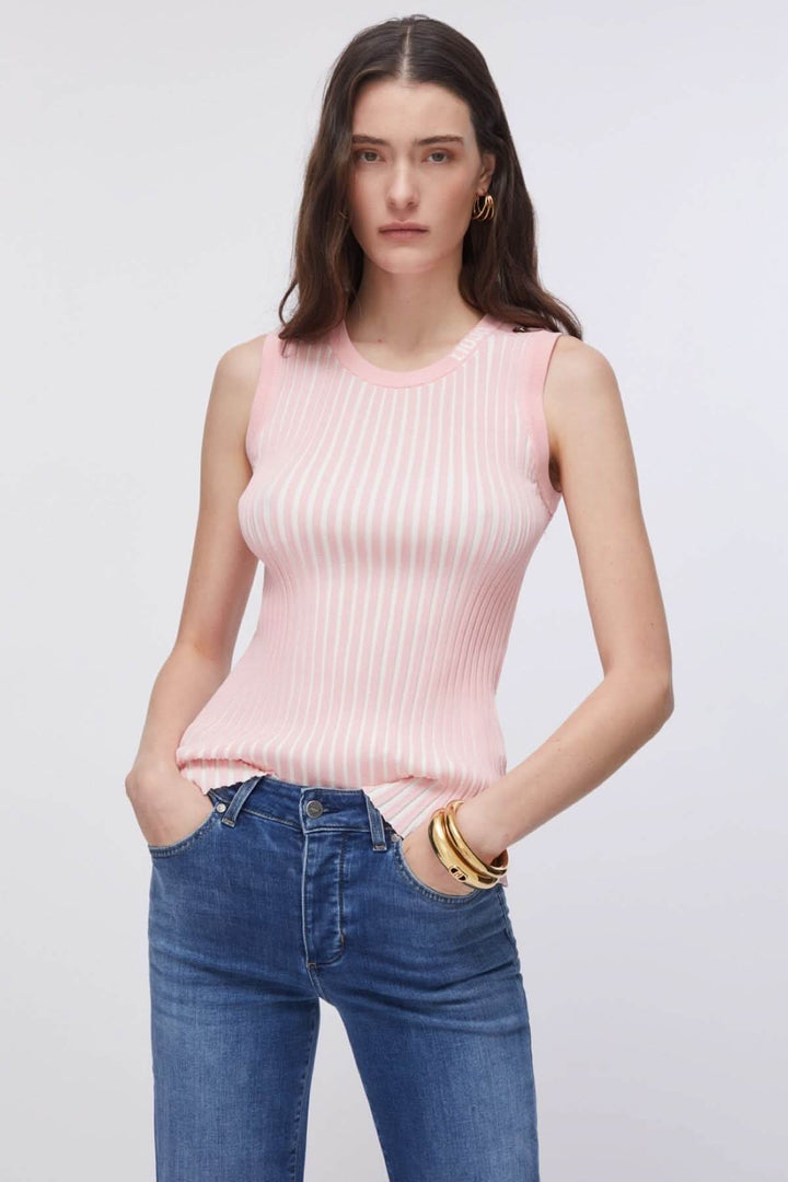 Femme portant une camisole en maille côtelée rose, sans manches, ajustée et confortable, associée à un jean pour un look moderne.