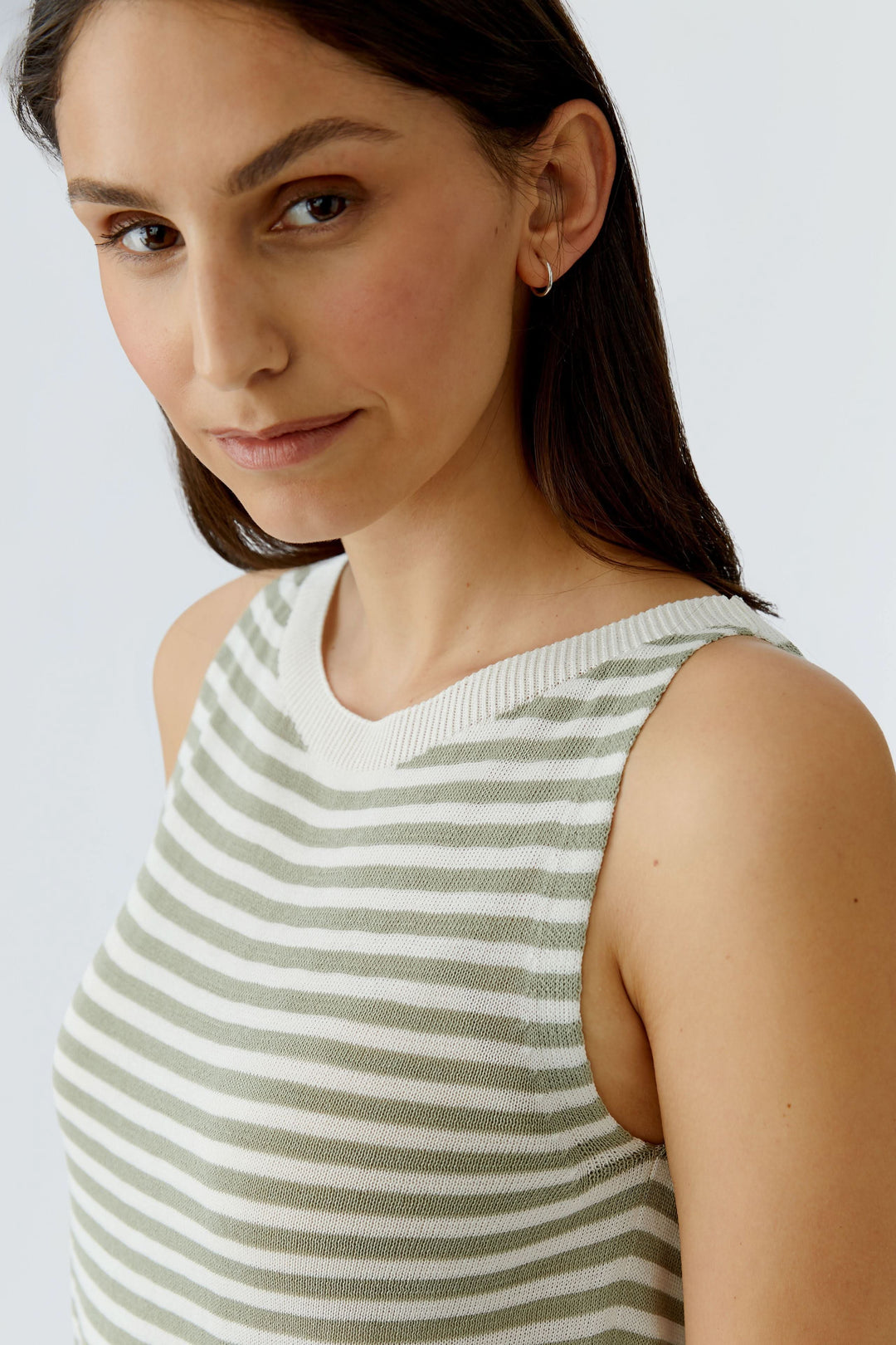 Femme portant une camisole en maille à rayures vertes et blanches, sans manches et à encolure ronde, style décontracté