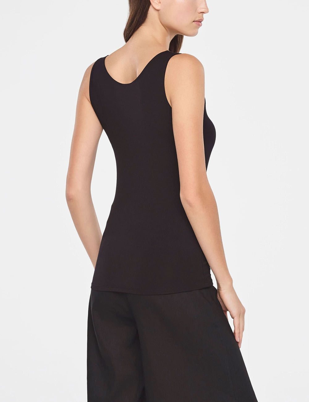 Camisole essentielle ajustée sans manches en tissu extensible, vue de dos sur mannequin, couleur noire, coupe minimaliste.