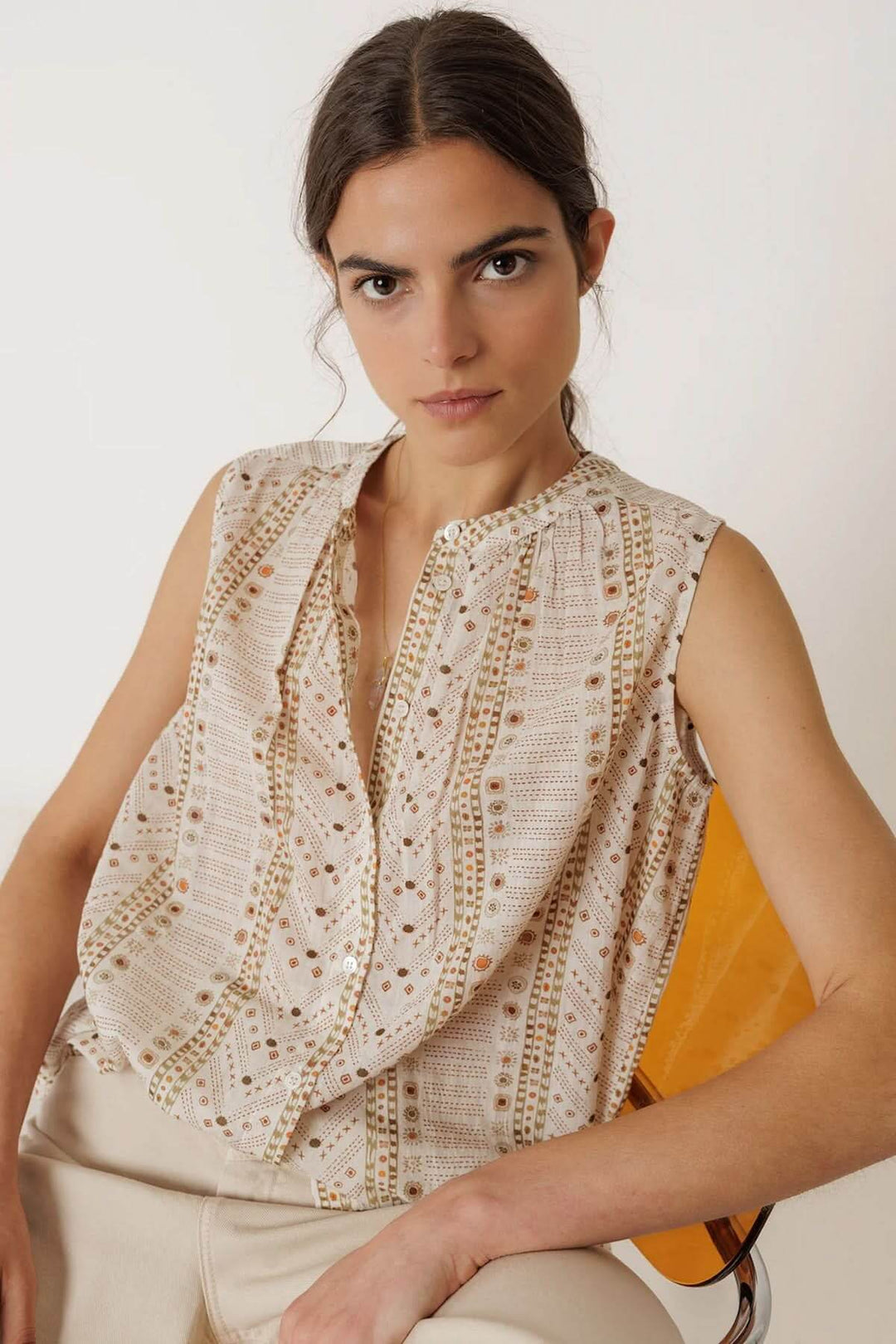 Femme portant une camisole fluide imprimée sans manches avec encolure ronde, tombé élégant et légèrement ample, parfait pour l&