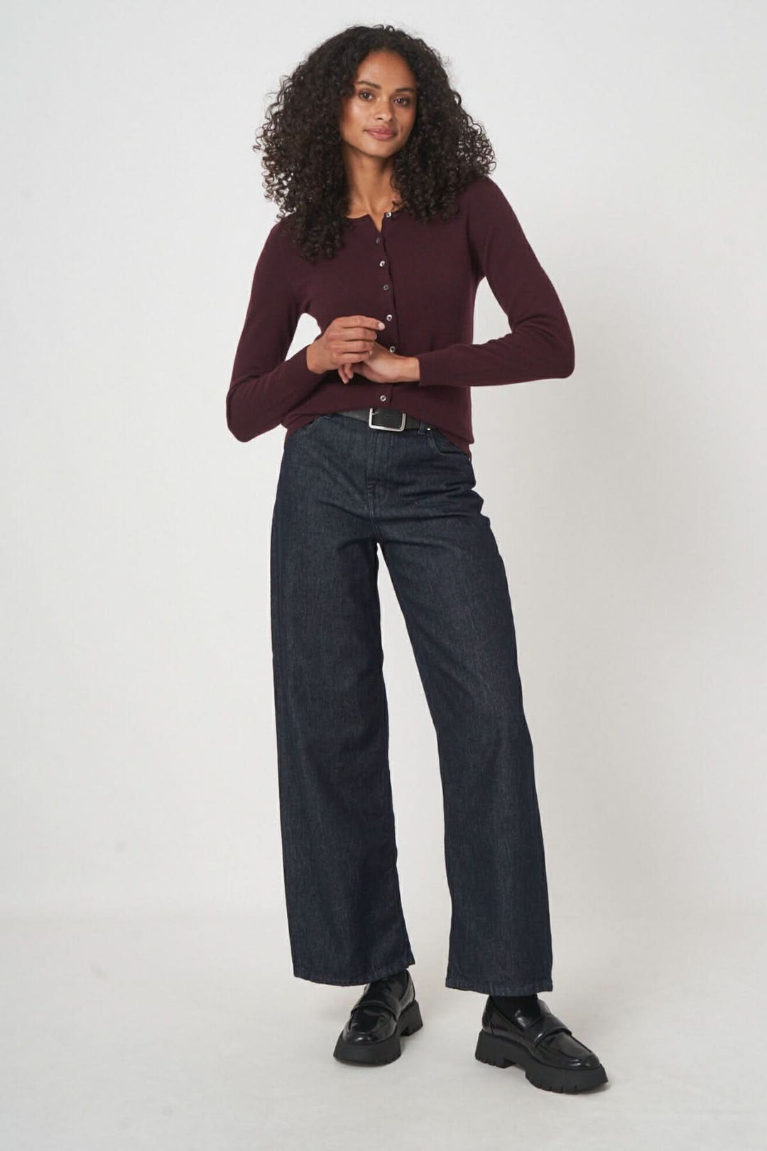 Femme portant un cardigan classique bordeaux avec des jeans, style casual chic.