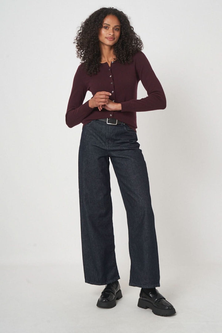 Femme portant un cardigan classique bordeaux avec des jeans, style casual chic.