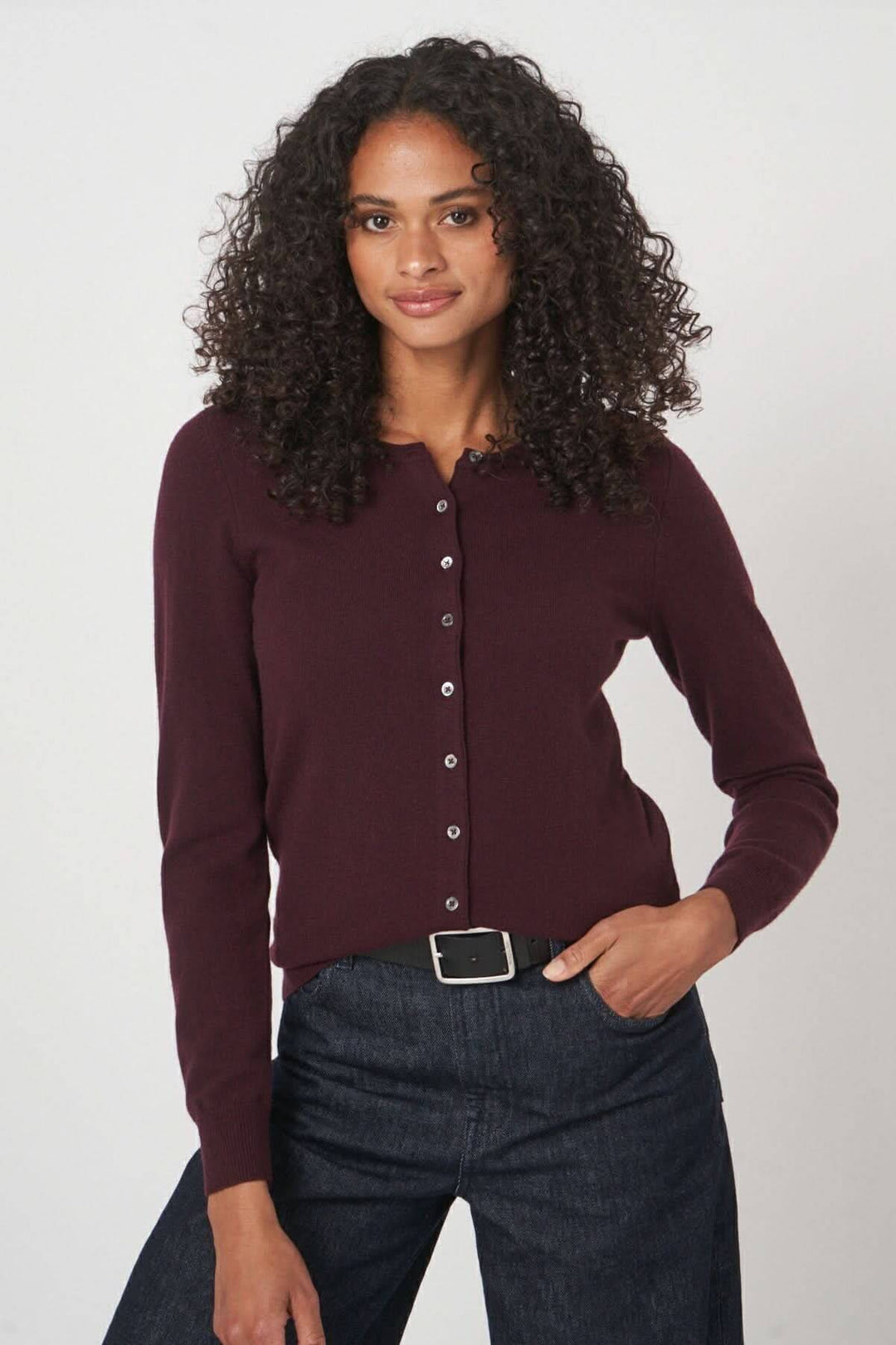 Cardigan classique boutonné en mailles douces, coupe ajustée, couleur bordeaux, porté avec un pantalon en denim.