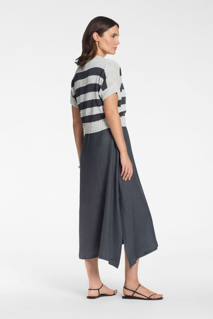 Femme portant un cardigan court à rayures col v, avec une jupe longue, vue de dos.