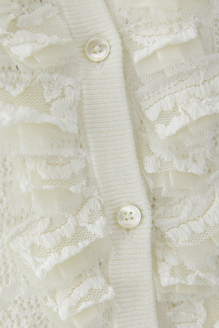 Cardigan en maille ajourée à volants avec boutons et détails en volants élégants.