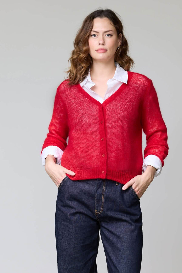 Femme portant un cardigan en mohair léger rouge avec encolure en V, parfait pour superposer, coupe féminine et élégante.