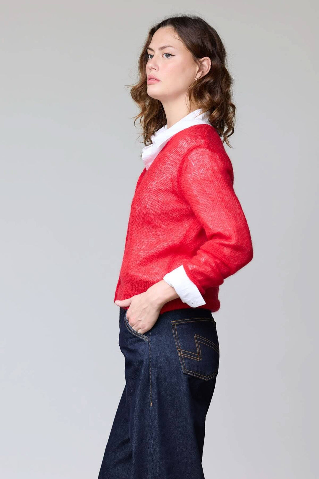 Femme portant un cardigan en mohair léger rouge avec chemise, coupe droite, élégant et vaporeux.