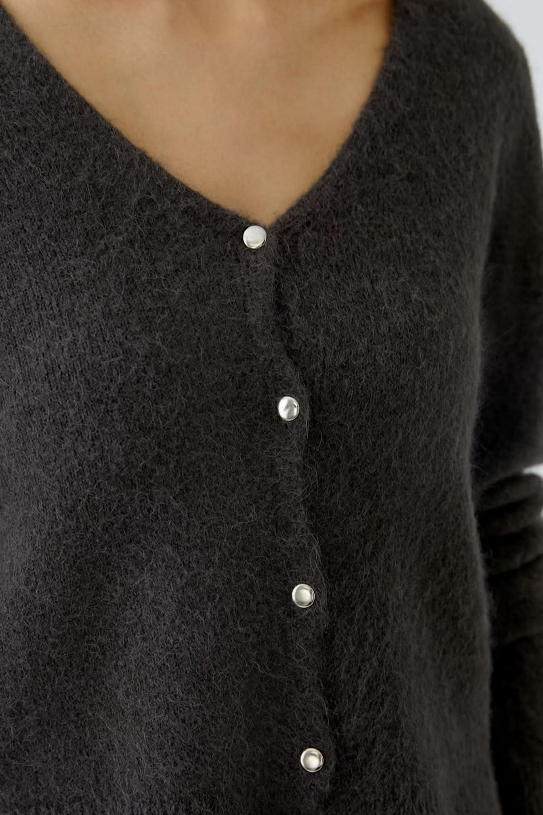 Cardigan à encolure en V avec boutons contrastés, maille duveteuse et coupe courte féminine, idéal pour un look polyvalent.