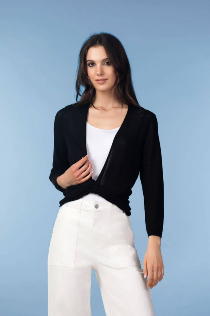 Femme portant un cardigan léger ouvert noir élégant, sur fond bleu.
