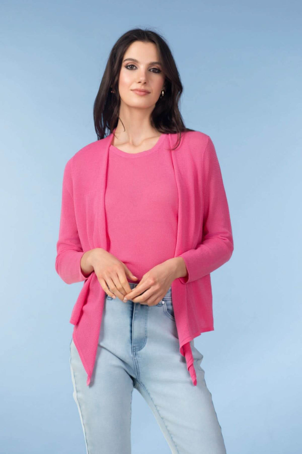 Femme portant un cardigan léger ouvert rose, manches longues, sur un t-shirt rose, idéal pour une tenue estivale ou de mi-saison.