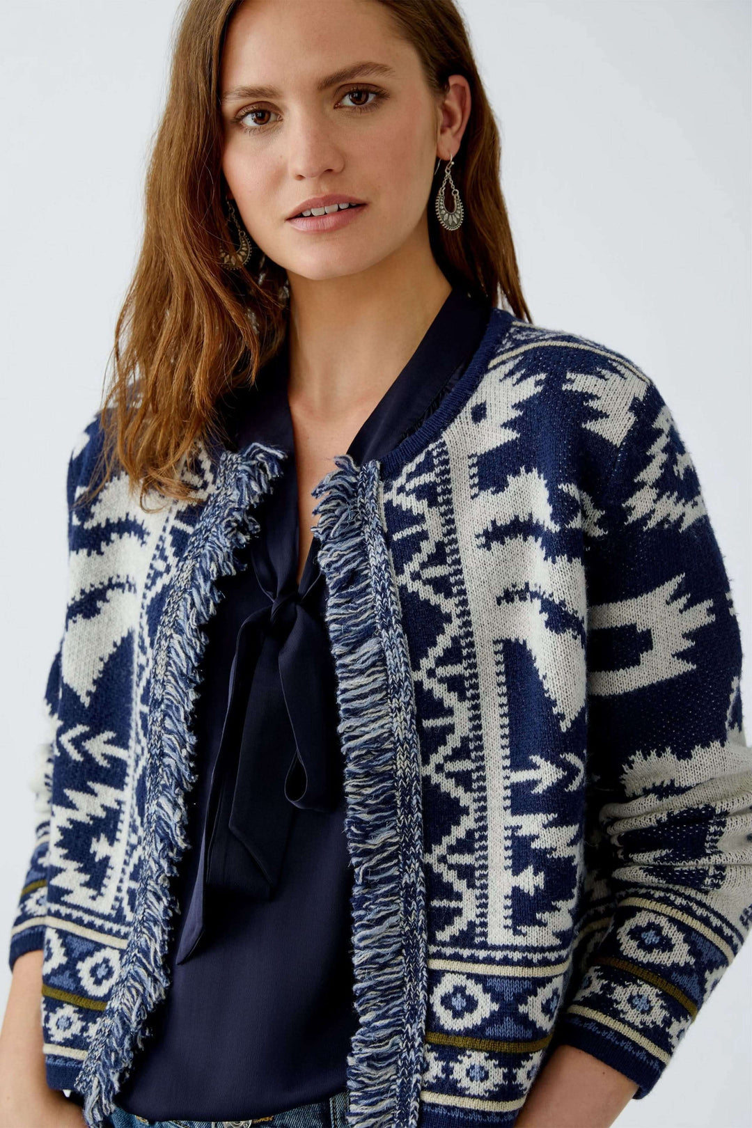 Cardigan motif western en jacquard avec franges, coupe moderne et col rond, porté par une femme.