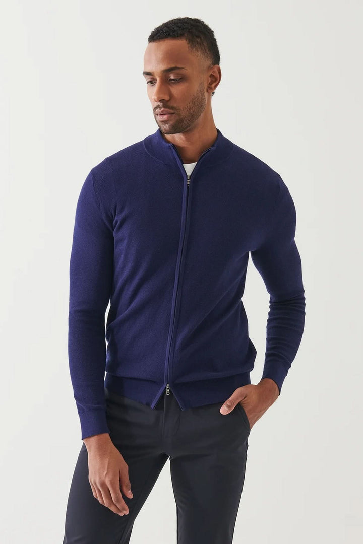 Cardigan zippé en coton et cachemire, couleur bleu marine, alliant élégance et confort, porté par un homme.