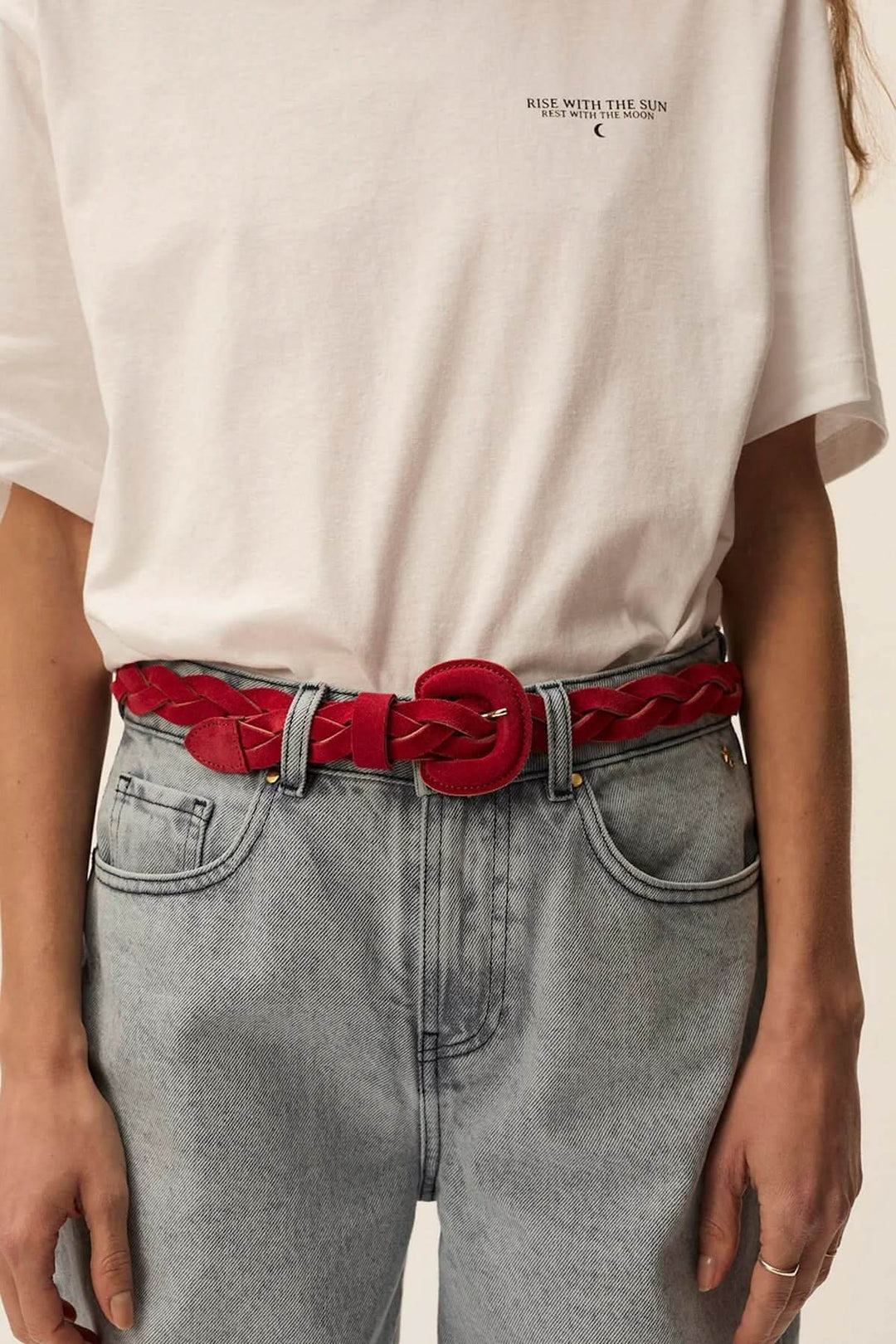 Ceinture Pigna en suède tressé rouge, ajoutant une touche artisanale à une tenue décontractée.