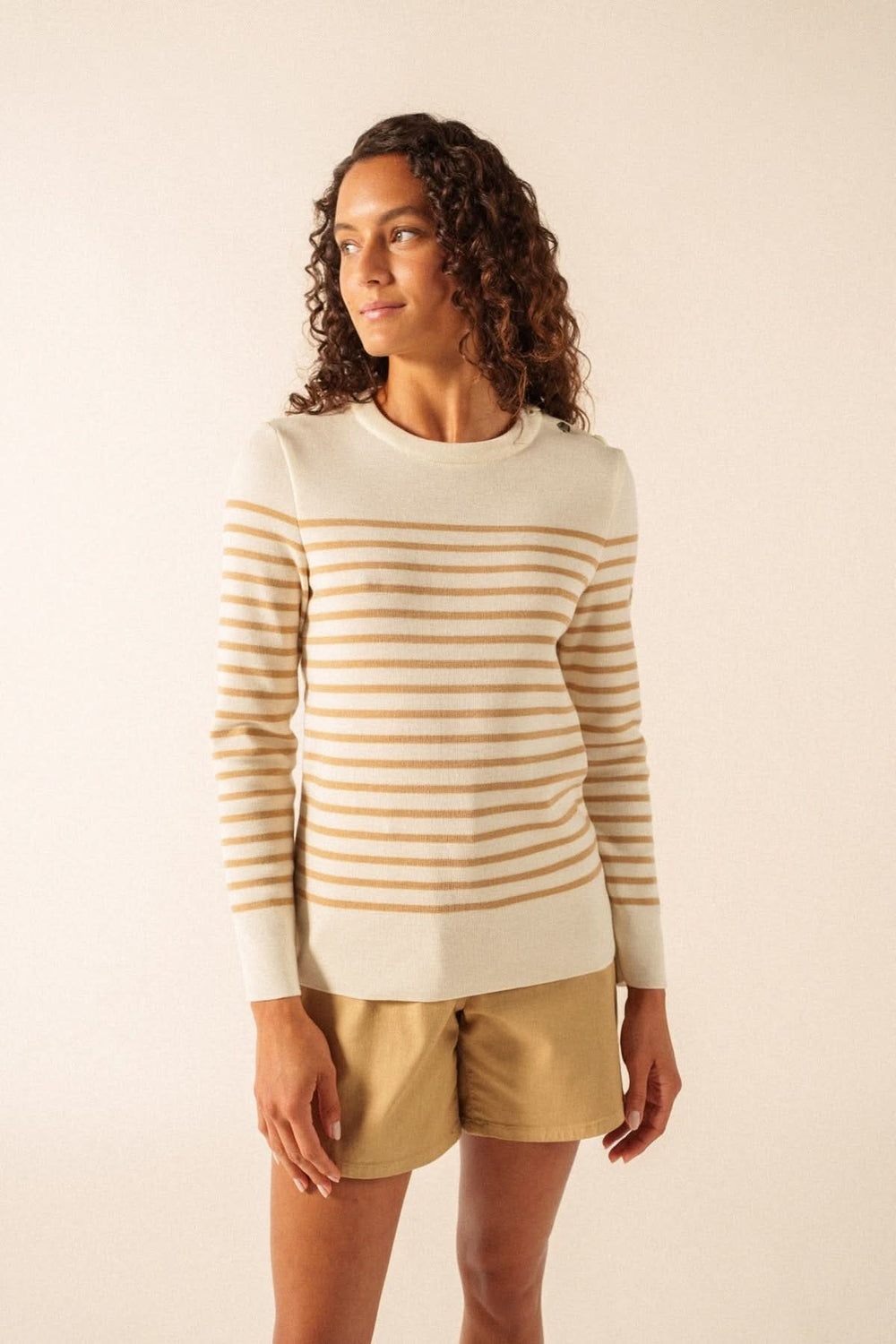 Femme portant un Chandail BREGANCON R POP rayé avec coudières assorties et col boutonné sur l'épaule gauche, style marin classique.